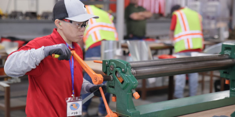 Image shows Rebecca Suen, sheet metal apprentice, working in a sheet metal fabrication shop.