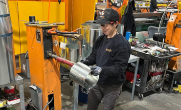Image shows Rebecca Suen, sheet metal apprentice, working in a sheet metal fabrication shop.